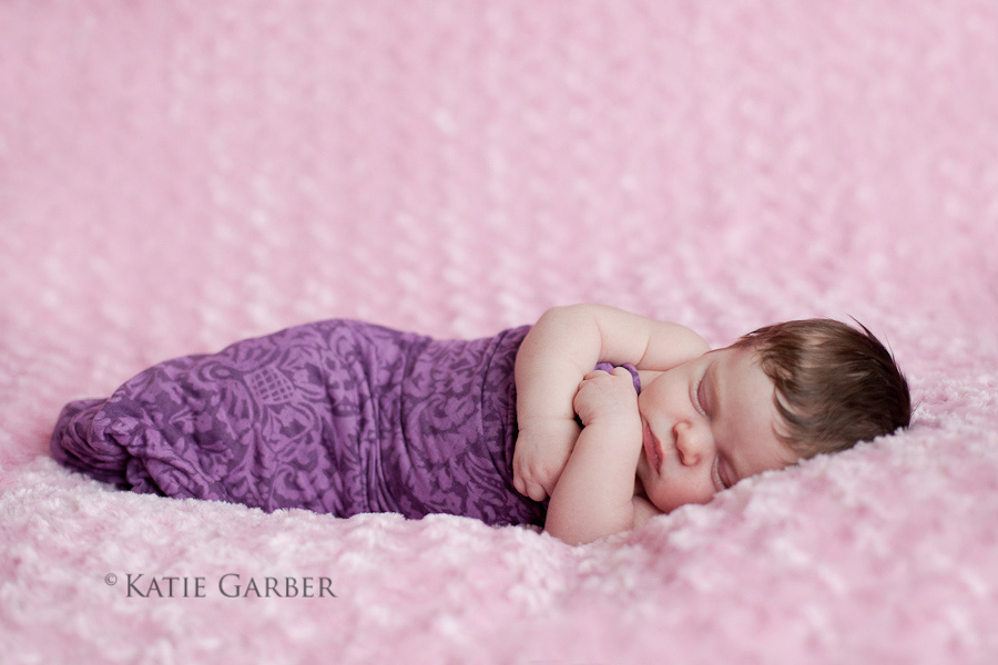 baby girl sleeping on pink blanket