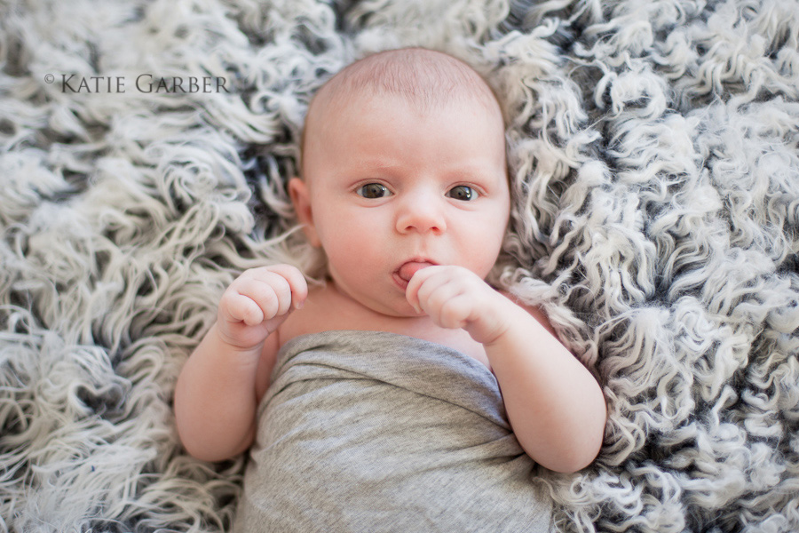swaddled baby on fur blanket
